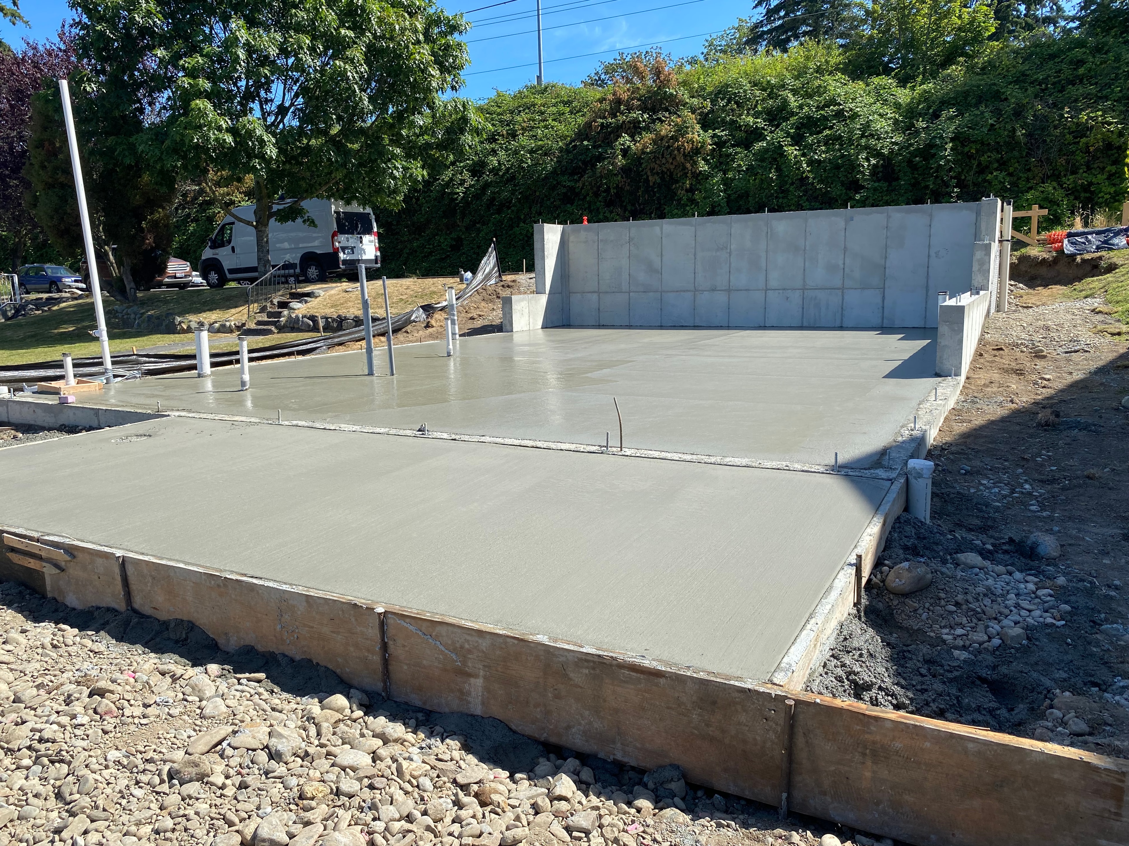 Concrete foundation slab with retaining wall